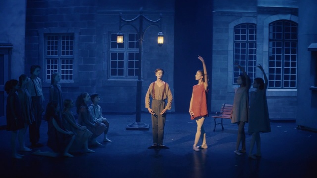 Video Reference: Blue, Performing arts, Performance, Stage, Scene, Musical, Drama, Fashion, Musical theatre, Heater, Person, Building, Outdoor, Front, Standing, Man, Walking, People, Young, Child, Woman, Room, Group, Girl, Holding, Playing, Street, Boy, Living, Clothing, Dance, Footwear