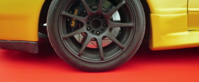 Video Reference: Alloy wheel, Tire, Rim, Wheel, Spoke, Automotive tire, Auto part, Automotive wheel system, Vehicle, Car, Indoor, Sitting, Table, Red, Yellow, Black, Small, Dog, Desk, Phone, Automotive, Tire care, Hubcap, Tread, Synthetic rubber, Transport, Land vehicle, Locking hubs