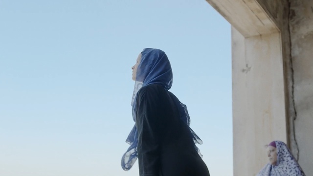 Video Reference: Hair, Blue, Sky, Standing, Outerwear, Headgear, Photography, Architecture, Long hair, Neck, Person