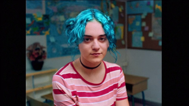 Video Reference: Hair, Face, Blue, Forehead, Head, Eyebrow, Hairstyle, Lady, Cheek, Chin, Person, Indoor, Table, Front, Young, Woman, Holding, Sitting, Looking, Food, Man, Striped, Shirt, Using, Standing, Girl, Birthday, Playing, Cake, Pizza, Computer, Room, Kitchen, White, Plate, Phone, Human face, Clothing, Portrait