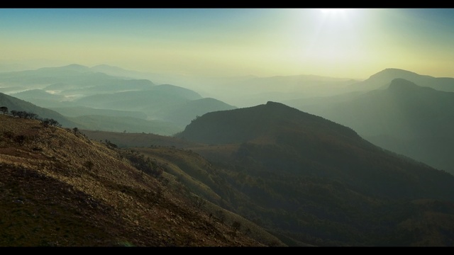 Video Reference: Mountainous landforms, Mountain, Highland, Sky, Nature, Hill, Ridge, Atmospheric phenomenon, Mountain range, Fell, Outdoor, Background, View, Large, Standing, Overlooking, Green, Side, Field, Grassy, Sheep, Desert, Tall, Lake, Cloudy, High, Grazing, Water, Fog, Landscape, Cloud, Distance, Hillside, Land