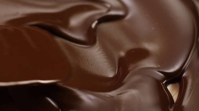Video Reference: Chocolate, Ganache, Brown, Close-up, Chocolate syrup, Dessert, Food, Dulce de leche, Caramel color, Chocolate pudding, Indoor, Sitting, Table, Black, Close, White, Mouse, Cake, Keyboard, Laying, Coffee, Plate, Design