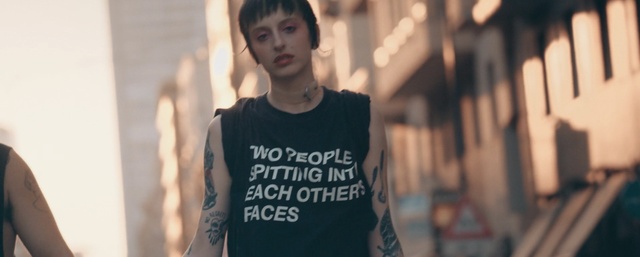 Video Reference: T-shirt, Street fashion, Fashion, Cool, Human, Top, Smile, Neck, Black hair, Style, Person, Building, Young, Boy, Holding, Standing, Little, Front, Shirt, Wearing, Woman, Black, Man, Girl, Table, Underwear, Board, Kitchen, White, Remote, Riding, Human face, Clothing, Text, Sleeve, Active shirt