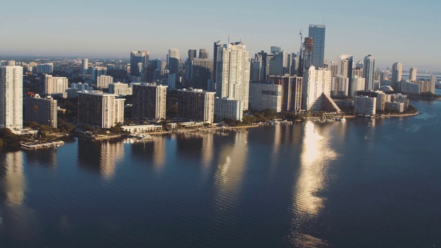 Video Reference: Cityscape, City, Metropolitan area, Skyline, Metropolis, Urban area, Daytime, Skyscraper, Human settlement, Sky, Person, Outdoor, Water, Harbor, Small, Background, Boat, Large, River, Body, Sunset, Ocean, Riding, Building, Lake, Tower, Scene, Day