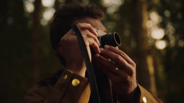 Video Reference: Photography, Hand, Tree, Outerwear, Glasses, Audio equipment, Brown hair, Jacket, Cameras & optics, Camera