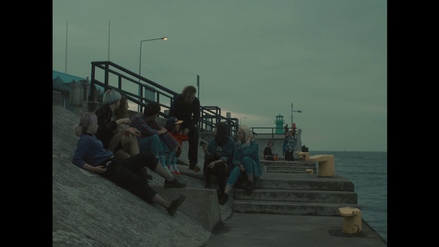 Video Reference: Snapshot, Sea, Sitting, Photography, Pier, Ocean, Walkway, Boardwalk, Water, Man, Building, Looking, Watching, Small, People, Boat, Jumping, Boy, Doing, Woman, Young, Group, Light, Holding, Bench, Trick, Air, Standing, Game, Board, Room, Riding, Flying, Sky, Person, Ship, Clothing