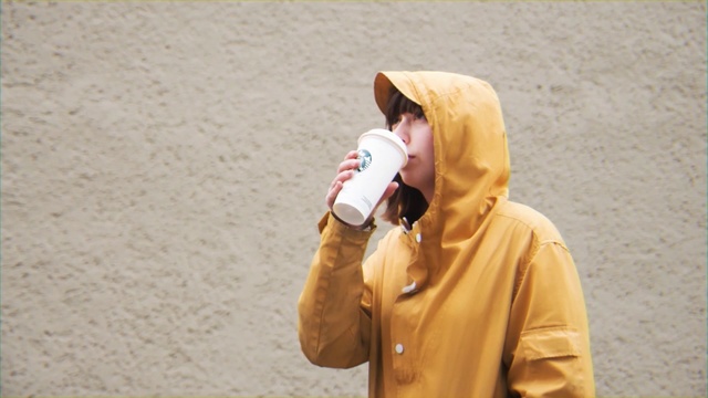 Video Reference: Outerwear, Landscape, Tourism, Smile, Person, Outdoor, Man, Holding, Cellphone, Standing, Wearing, Beach, Phone, Yellow, Young, Hat, Hand, Suit, Talking, Woman, Boy, Sand, White, Walking, Ball, Playing, Shirt, Player, Street, Baseball, Ground, Human face, Clothing, Fashion accessory, Jacket