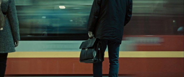 Video Reference: Standing, Blue, Baggage, Green, Shoulder, Snapshot, Luggage and bags, Bag, Hand luggage, Joint, Person, Indoor, Man, Television, Window, Monitor, Holding, Front, Bus, Woman, Playing, Train, Room, Screen, Riding, Platform, Video, Yellow, Walking, Blurry, Board, Remote, Living, Subway, Game, People, Street, Luggage, Coat, Trousers, Jacket, Handbag, Clothing, Footwear, Boot, Jeans, High heels, Fashion accessory, Street fashion