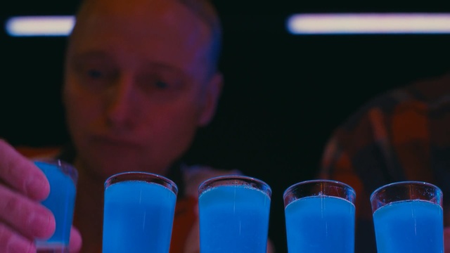 Video Reference: Drink, Person, Indoor, Table, Cup, Man, Glasses, Food, Front, Sitting, Looking, Holding, Hand, Small, Glass, Close, Young, Woman, Computer, Orange, Phone, Red, Sandwich, White, Standing, Soft drink, Cocktail, Juice, Beverage