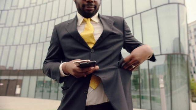 Video Reference: Suit, Formal wear, Blazer, White-collar worker, Outerwear, Tuxedo, Street fashion, Businessperson, Jacket, Gadget