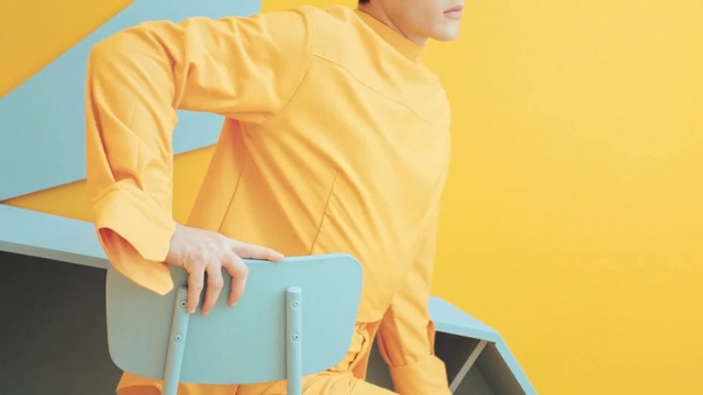 Video Reference: Yellow, Clothing, Orange, Sleeve, Shoulder, Outerwear, Workwear, Neck, Joint, Shirt
