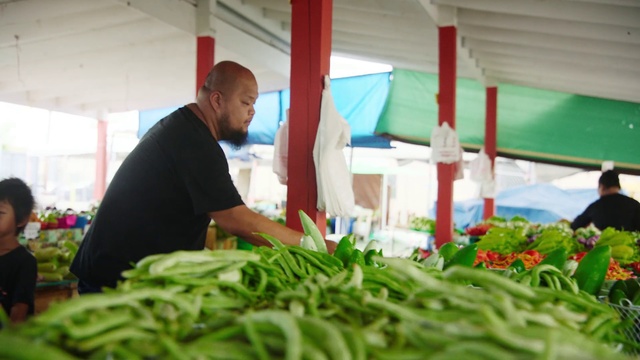 Video Reference: Local food, Vegetable, Plant, Grass, Leaf vegetable, Selling, Vegetarian food, Person, Table, Indoor, Food, Man, Green, Looking, Sitting, Front, Standing, Preparing, Kitchen, Large, Woman, People, Produce, Cake, Cutting, Young, Fruit, Group, Holding, Plate, Board, Pizza, White, Fresh
