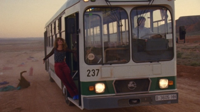 Video Reference: Land vehicle, Vehicle, Transport, Mode of transport, Bus, Car, Motor vehicle, Commercial vehicle, Public transport, Automotive exterior, Small, Sitting, Man, People, Parked, Green, Standing, Table, Woman, White, Group, Street, Train, Large, Young, Riding, Bed, Living, Room, Track