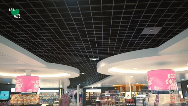 Video Reference: Ceiling, Building, Architecture, Interior design, Sky, Shopping mall, Table, Sitting, Station, Large, Bus, Area, People, Green, Food, White, Filled, Light, Parked, Display, Lot, Man, Restaurant, Room, Standing, Parking, Group, Plane, Luggage, Red, Airplane, Store, City, Train, Sign, Motorcycle, Text