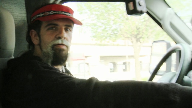 Video Reference: car, facial hair, vehicle, beard, automotive exterior, window, driving, Person