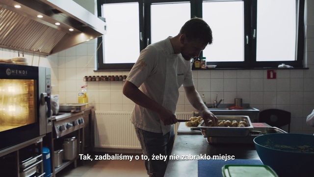 Video Reference: Cook, Cooking, Room, Food, Meal, Cookware and bakeware, Kitchen, Dish, Cuisine, Indoor, Person, Man, Preparing, Window, Table, Standing, Woman, Holding, Large, Counter, Wearing, Computer, Stove, Pan, People, Plate, Text, Kitchen appliance