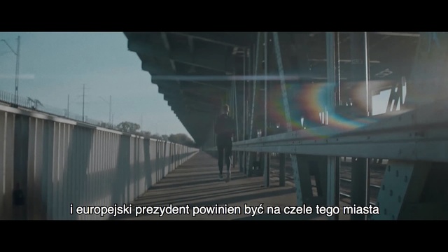 Video Reference: Bridge, Fixed link, Atmospheric phenomenon, Snapshot, Architecture, Mode of transport, Atmosphere, Overpass, Sky, Photography, Outdoor, Building, Sitting, Water, Table, Large, Glass, Street, Train, City, Light, Green, Bus, Holding, Rain, White, Man, Bird, Track, Standing, Traffic, Text, Screenshot, Fog, Video game