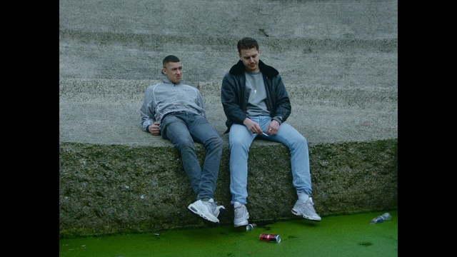 Video Reference: green, blue, white, man, photograph, nature, sitting, grass, male, leisure, Person