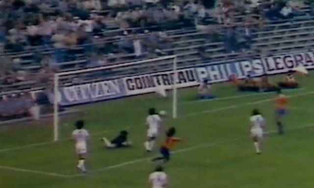 Video Reference: Player, Stadium, Sport venue, Sports, Soccer player, Football, Sports equipment, Soccer, Team sport, Ball game, Grass, Building, Outdoor, Field, Playing, Green, Ball, Man, Large, Game, People, Standing, Woman, Crowd, Group, Grassy, Airplane, Air, Match, Plane, White, Blue, Person