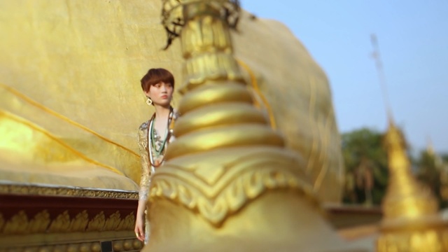 Video Reference: yellow, statue, religion, sky, temple, monument, temple, wat, place of worship, Person