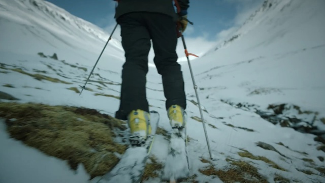 Video Reference: mountaineering, ski pole, ski touring, footwear, ridge, ski mountaineering, mountaineer, mountainous landforms, mountain range, geological phenomenon, Person
