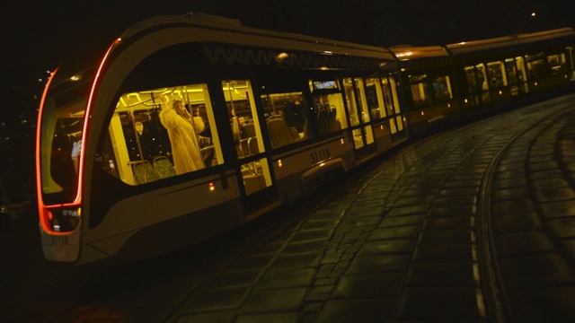 Video Reference: yellow, public transport, night, mode of transport, transport, light, rapid transit, train, darkness, lighting