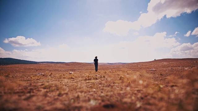 Video Reference: Sky, Natural environment, Cloud, Ecoregion, Horizon, Sand, Desert, Plain, Landscape, Tree, Person, Outdoor, Field, Kite, Standing, Grass, Dry, Flying, Open, Background, Man, Beach, Area, Large, Mountain, Hill, Grassy, Walking, Blue, Sunset, Holding, People, Tall, Group, Nature, Hiking, Distance, Day, Soil