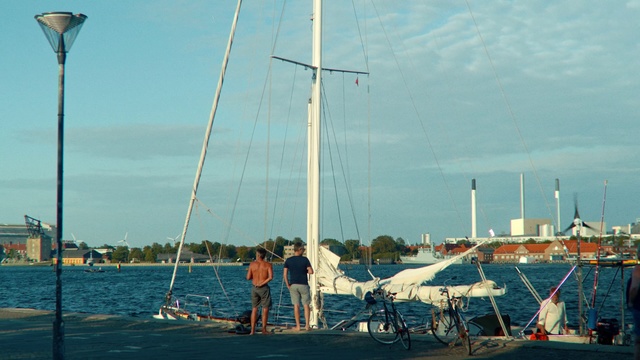 Video Reference: Boat, Vehicle, Sailboat, Sailing, Mast, Yacht, Watercraft, Sail, Marina, Wind, Outdoor, Water, Pier, Dock, Docked, Sitting, Ship, Small, Lake, Group, Body, Man, Standing, Front, People, Ocean, Parked, Large, Woman, Old, Wooden, Blue, White, Holding, Beach, Riding, Sky, Transport, Sailing vessel, Tied, Several