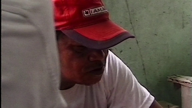 Video Reference: Red, Clothing, Cap, Hat, T-shirt, Nose, Baseball cap, Headgear, Facial hair, Sleeve