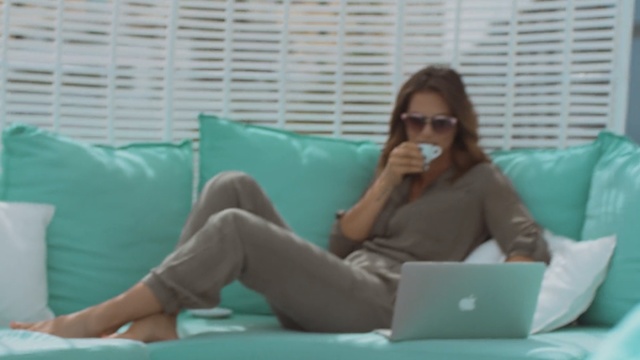 Video Reference: Turquoise, Leg, Leisure, Sitting, Glasses, Pillow, Furniture, Linens, Room, Electronic device, Person