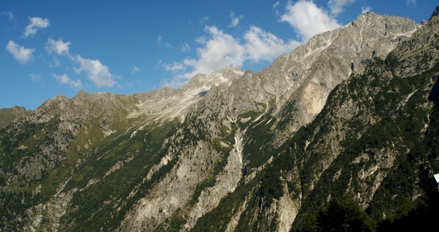 Video Reference: Mountainous landforms, Mountain, Mountain range, Ridge, Highland, Arête, Alps, Massif, Wilderness, Hill station, Outdoor, Nature, Snow, Rock, Covered, Side, Background, Standing, Hillside, Rocky, Hill, View, Man, Group, Large, Skiing, Slope, Walking, Green, Field, People, Grassy, Tall, White, Grazing, Horse, Herd, Riding, Sky, Cloud, Landscape