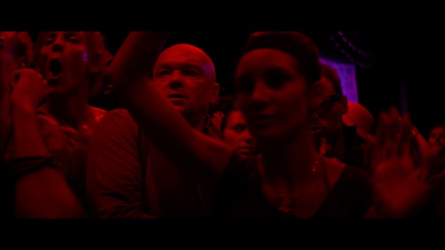 Video Reference: Red, Light, Magenta, Fun, Event, Room, Performance, Darkness, Photography, Performance art, Person, Indoor, Man, Sitting, Dark, Fire, Table, Looking, Lit, People, Laptop, Front, Group, Holding, Using, Video, Playing, Screen, Woman, Computer, Game, Bed, Standing, Night, Human face, Crowd