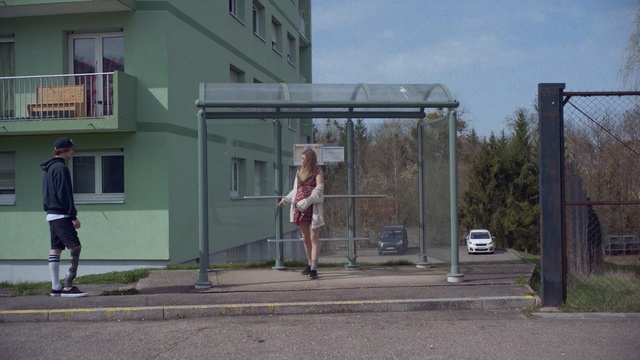 Video Reference: public space, structure, infrastructure, town, city, bus stop, house, residential area, recreation, sports, Person