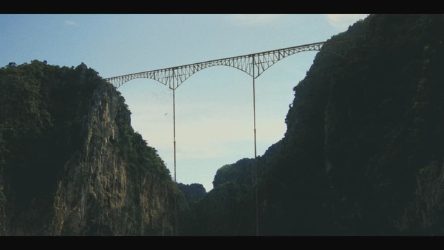 Video Reference: sky, bridge, arch bridge, fixed link, suspension bridge, mountain, escarpment, terrain, cliff, bungee jumping