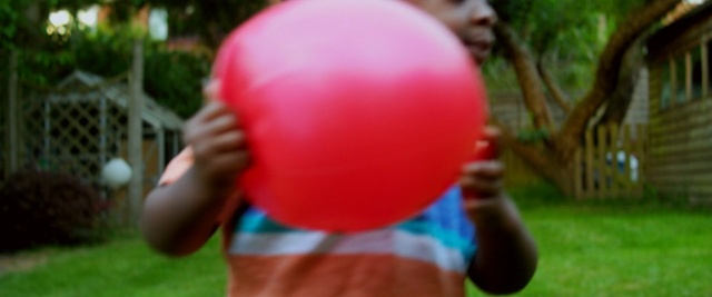 Video Reference: red, pink, balloon, grass, fun, play, toy, child, party supply, lawn, Person