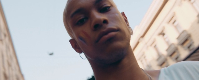 Video Reference: Face, Hair, Nose, Facial expression, Skin, Chin, Head, Neck, Forehead, Eyebrow, Person, Looking, Man, Front, Wearing, Standing, Camera, Shirt, Holding, White, Close, Smiling, Mirror, Glasses, Young, Red, Blue, Woman, Phone, Sign, Sky, Human face, Eyes, Selfie, Portrait, Staring