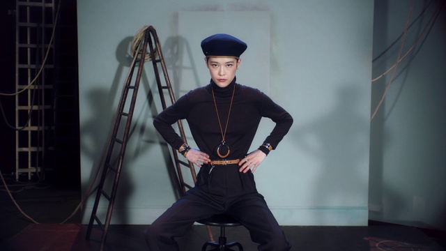 Video Reference: Fashion, Footwear, Photography, Headgear, Neck, Photo shoot, Shoe, Sitting, Fashion design, Person, Man, Holding, Wearing, Black, Front, Standing, Woman, Young, Using, Hat, Board, Dressed, Suit, Table, Computer, Water, Room, White, Phone, Umbrella, Clothing, Floor, Fashion accessory, Human face, Skirt, High heels