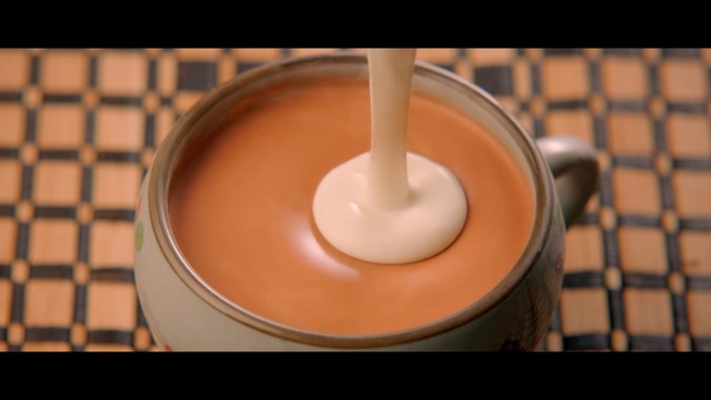 Video Reference: Food, Dairy, Cuisine, Cajeta, Dulce de leche, Cream, Drink, Dish, Ingredient, Condensed milk, Cup, Indoor, Table, Coffee, Sitting, Beverage, Keyboard, Orange, Small, Doughnut, Donut, Computer, Black, Bowl, Laptop, Desk, Plate, White, Cake, Pink, Smoothie, Oranges, Blue, Candle, Kitchen utensil, Tableware, Spoon, Milk, Serveware