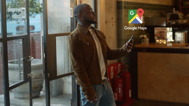 Video Reference: man, black man, door, window, hand, phone, map, bar, restaurant, Person