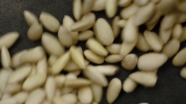 Video Reference: Pine nut, Food, Cuisine, Vegetarian food, Plant, Ingredient, Seed, Produce, Sunflower seed, Navy beans, Nut, Fruit, Sitting, Pile, Topped, Chocolate, Banana, Several, Plate, Fries, Table, Covered, White, Group, Nuts & seeds, Sliced, Vegetable
