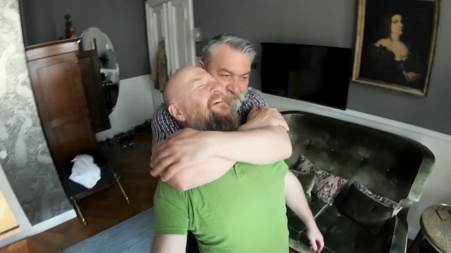 Video Reference: Shoulder, Arm, Joint, Muscle, Hug, Interaction, Leg, Room, Neck, Furniture, Person, Indoor, Man, Holding, Young, Standing, Shirt, Front, Living, Kitchen, Wearing, Boy, Woman, Food, Playing, Table, Green, Remote, Video, Pizza, Wall, Human face, Kiss