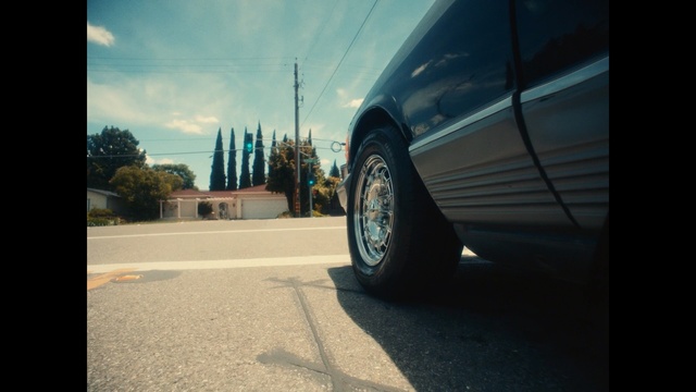 Video Reference: Vehicle, Car, Automotive tire, Tire, Wheel, Alloy wheel, Mode of transport, Automotive wheel system, Rim, Auto part, Outdoor, Road, View, Street, Side, Sitting, Mirror, Front, Light, Red, Traffic, White, Stop, City, Parked, Sunset, Bus, Riding, Sign, Blue, Sky, Land vehicle