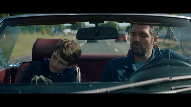 Video Reference: cabriolet, car, seat belt, safety belt, vehicle, driver, automobile, sitting, restraint, transportation, auto, driving, person, drive, car mirror, mirror, adult, people