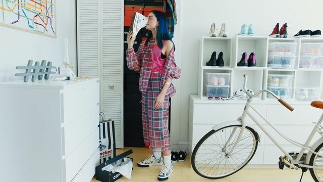Video Reference: Pink, Room, Shelf, Pattern, Plaid, Design, Fashion, Tartan, Textile, Furniture, Indoor, Bicycle, Kitchen, White, Table, Woman, Standing, Young, Sink, Man, Bedroom, Refrigerator, Dog, Living, Stove, Bicycle wheel, Clothing