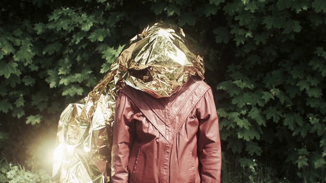 Video Reference: Outerwear, Jacket, Sunlight, Parka, Tree, Photography, Adaptation, Hood, Plant, Raincoat, Person, Outdoor, Clothing, Standing, Woman, Building, Holding, Man, Wearing, Front, Dress, Young, Posing, Forest, Walking, Suit, Covered, Street, White, Phone, Skiing, Field, Luggage and bags