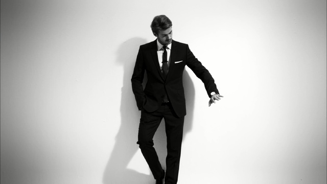 Video Reference: Suit, Photograph, Standing, White, Formal wear, Black, Gentleman, Male, Tuxedo, Black-and-white, Person