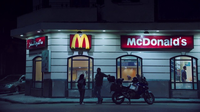 Video Reference: Building, Night, Signage, Vehicle, Automotive lighting, Advertising, Facade, Fast food restaurant, Street, Electronic signage, Person