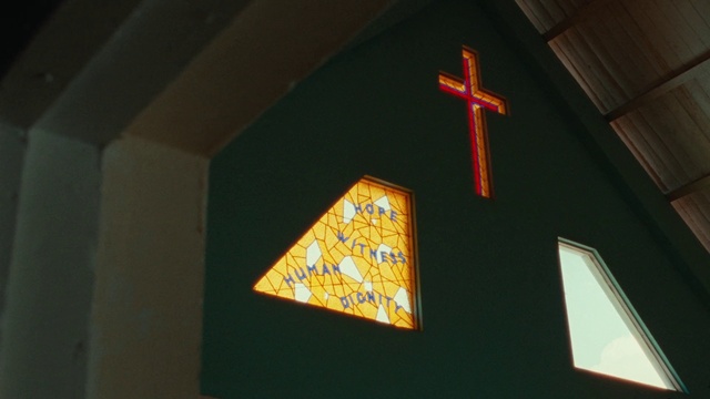 Video Reference: Amber, Wood, Triangle, Cross, Font, Religious item, Ceiling, Tints and shades, Symmetry, Space