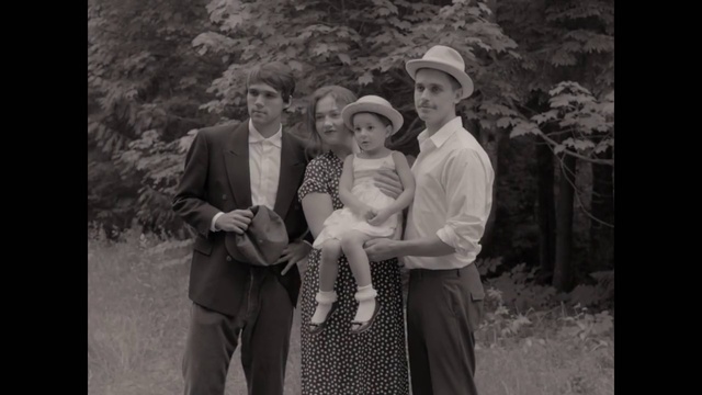 Video Reference: People, Photograph, Standing, Monochrome photography, Vintage clothing, Snapshot, Gentleman, Monochrome, Photography, Black-and-white, Person, Outdoor, Photo, Posing, Woman, Man, Holding, Suit, Black, Grass, Old, Front, Wearing, White, Hat, Young, Field, Smile, Clothing, Human face, Fashion accessory, Dress, Sun hat, Crowd