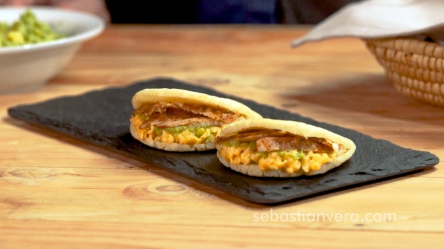 Video Reference: Dish, Food, Cuisine, Ingredient, Produce, Staple food, Baked goods, Fried food, Recipe, Finger food, Table, Wooden, Indoor, Sitting, Plate, Board, Cutting, Small, Wood, Bowl, Topped, Cake, Cheese, Fruit, Knife, Laying, White, Broccoli, Pizza, Fast food, Sandwich, Breakfast, Bread, Snack, Hamburger, Hot dog, Banh ma, Burger